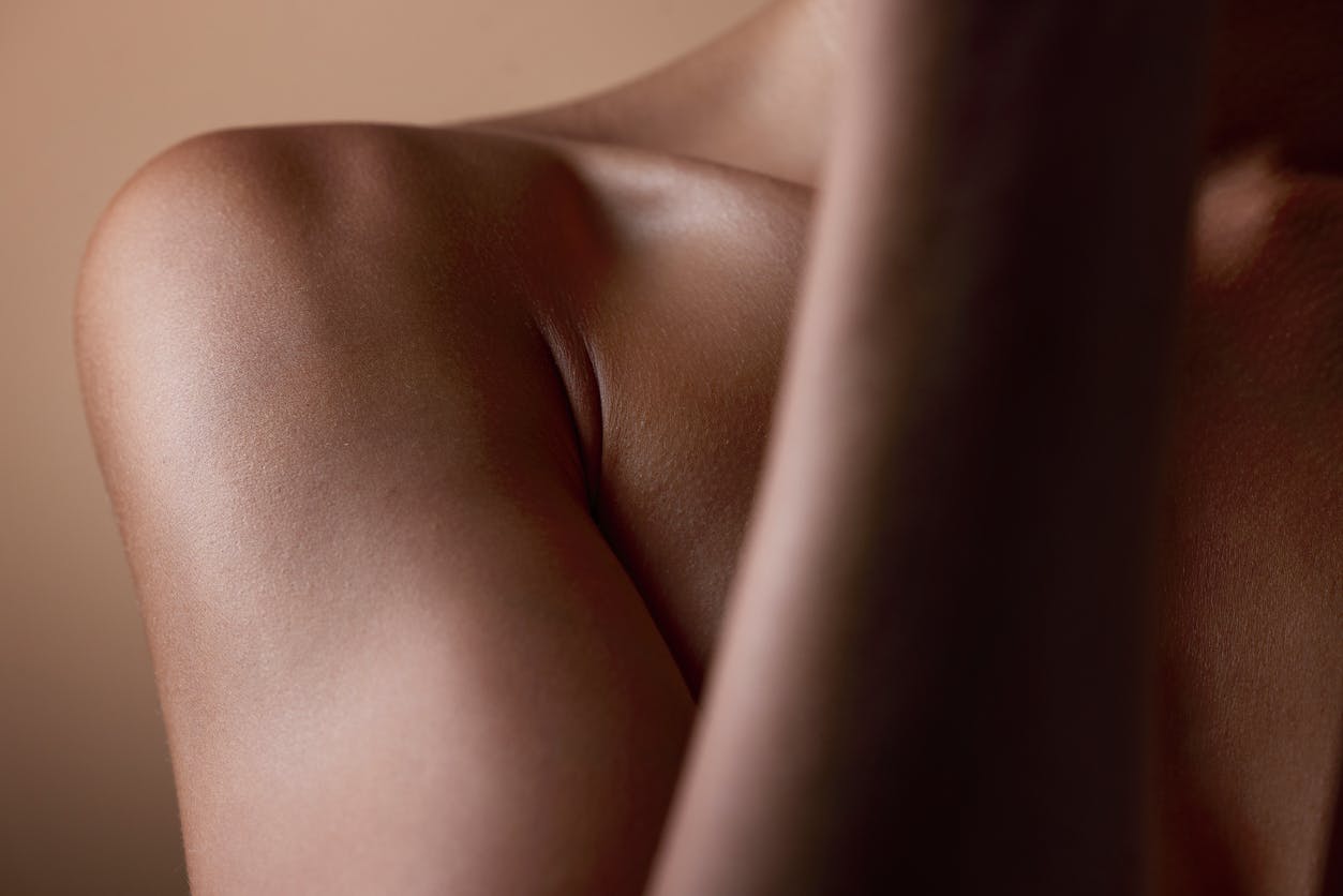 TIght shot of a black woman's shoulder with beautiful glowing skin