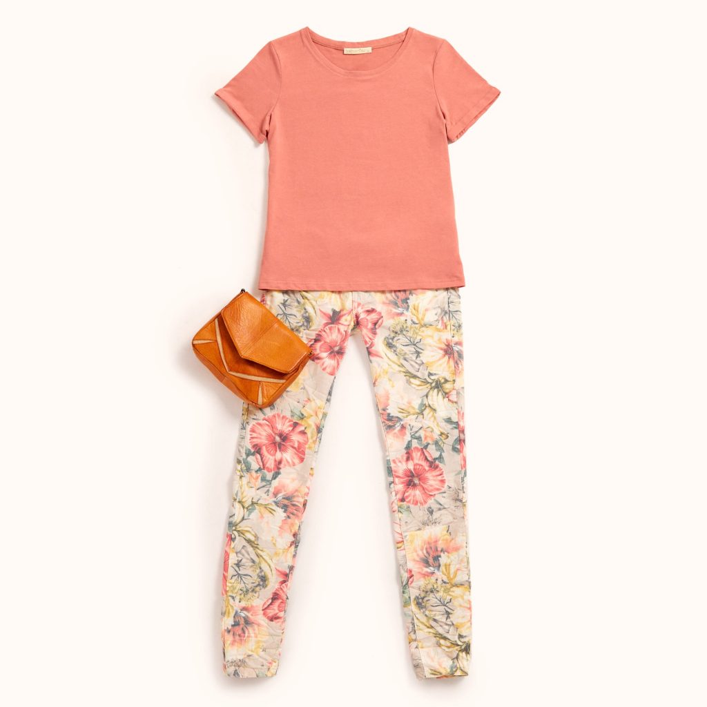 t-shirt básica em tom salmão conjugada com uns jeans de estampado floral maxi