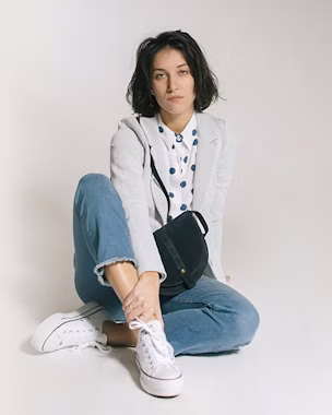 Vaqueros con blusa de lunares, un blazer y sneakers