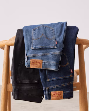 Mom jeans in different washes displayed on a chair – versatile for any outfit