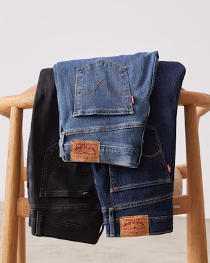 Mom jeans in different washes displayed on a chair – versatile for any outfit