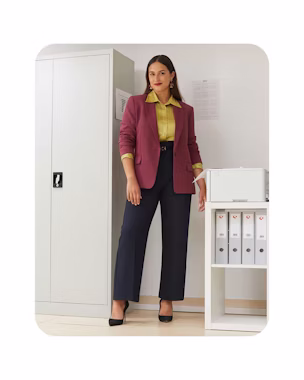 Woman in an office wearing a burgundy blazer, satin shirt and navy straight-leg trousers with black heels – inspiration for back-to-work 2025.