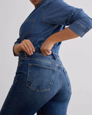 Frau in blauer High-Waist-Jeans, die die Silhouette streckt – ein Beispiel dafür, welche Jeans zu welcher Körperform am besten passt.