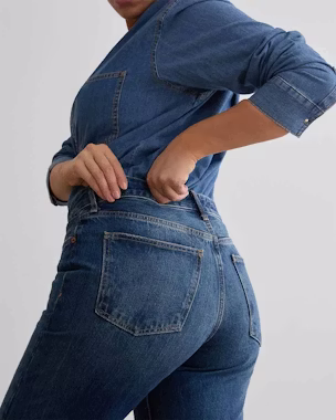 Frau in blauer High-Waist-Jeans, die die Silhouette streckt – ein Beispiel dafür, welche Jeans zu welcher Körperform am besten passt.