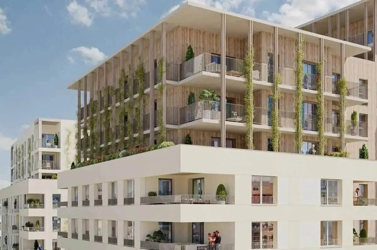 Façade moderne d’un grand immeuble de logements neufs ou réhabilités avec balcons végétalisés pour un investissement en déficit foncier.