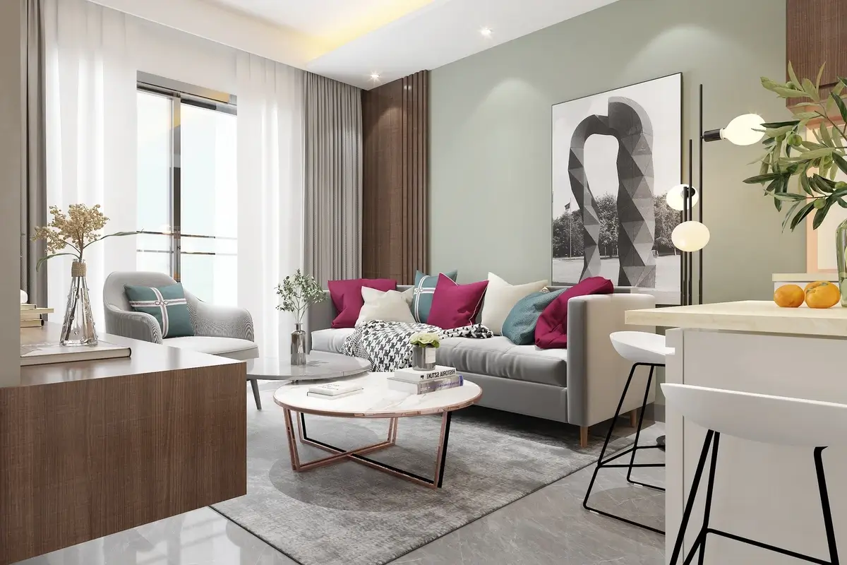 Salon contemporain d'un appartement meublé avec canapé gris, coussins colorés, tables basses en marbre et coin cuisine ouverte, parfait pour un investissement locatif LMNP ou LMP.