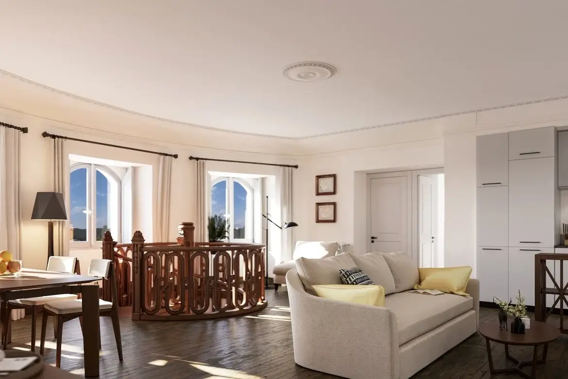 Intérieur d'un appartement de standing réhabilité, comprenant un salon lumineux avec canapé, du parquet ancien et une rambarde en bois sculpté, idéal pour un investissement locatif Malraux.
