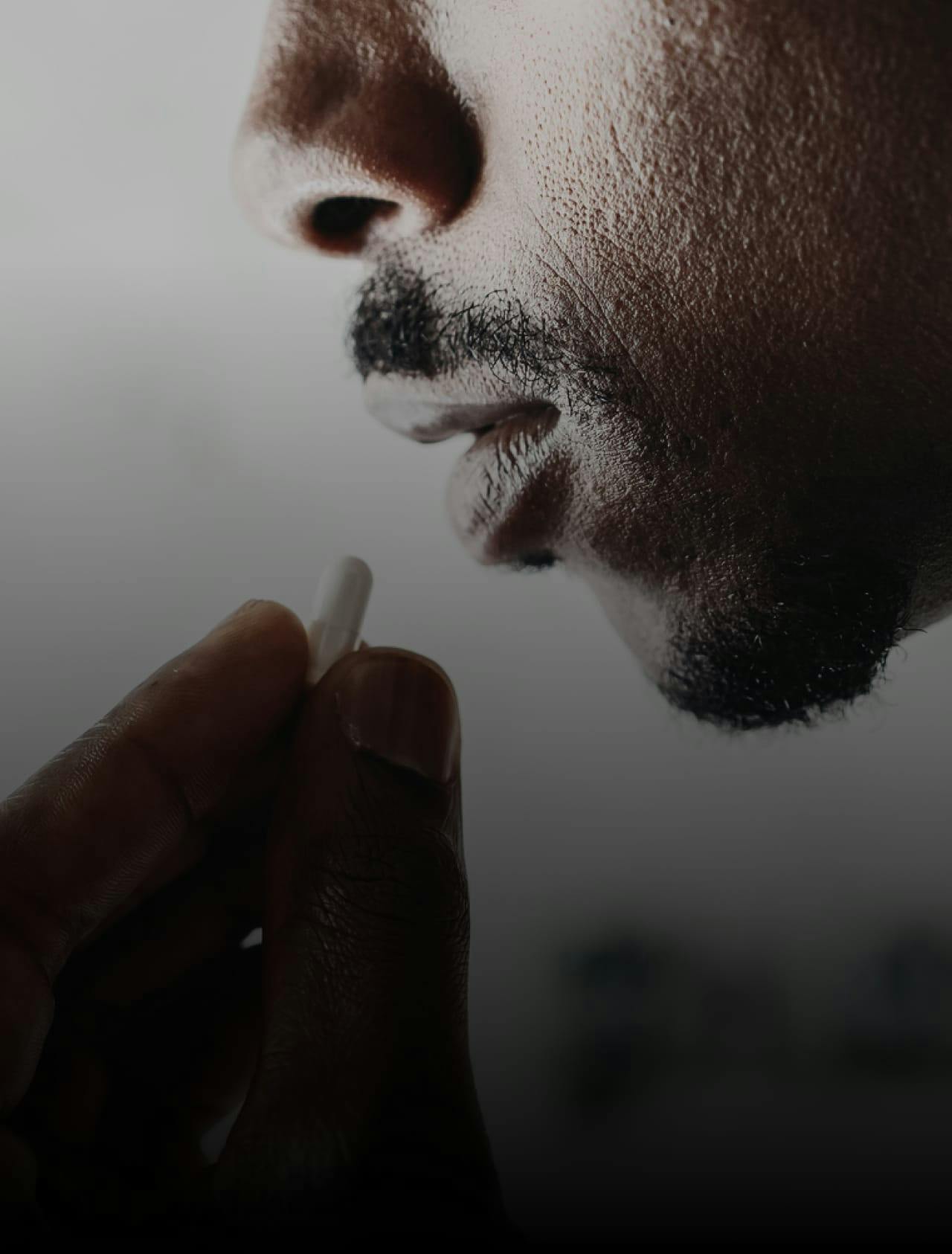 Closeup of a pill going into someone's mouth