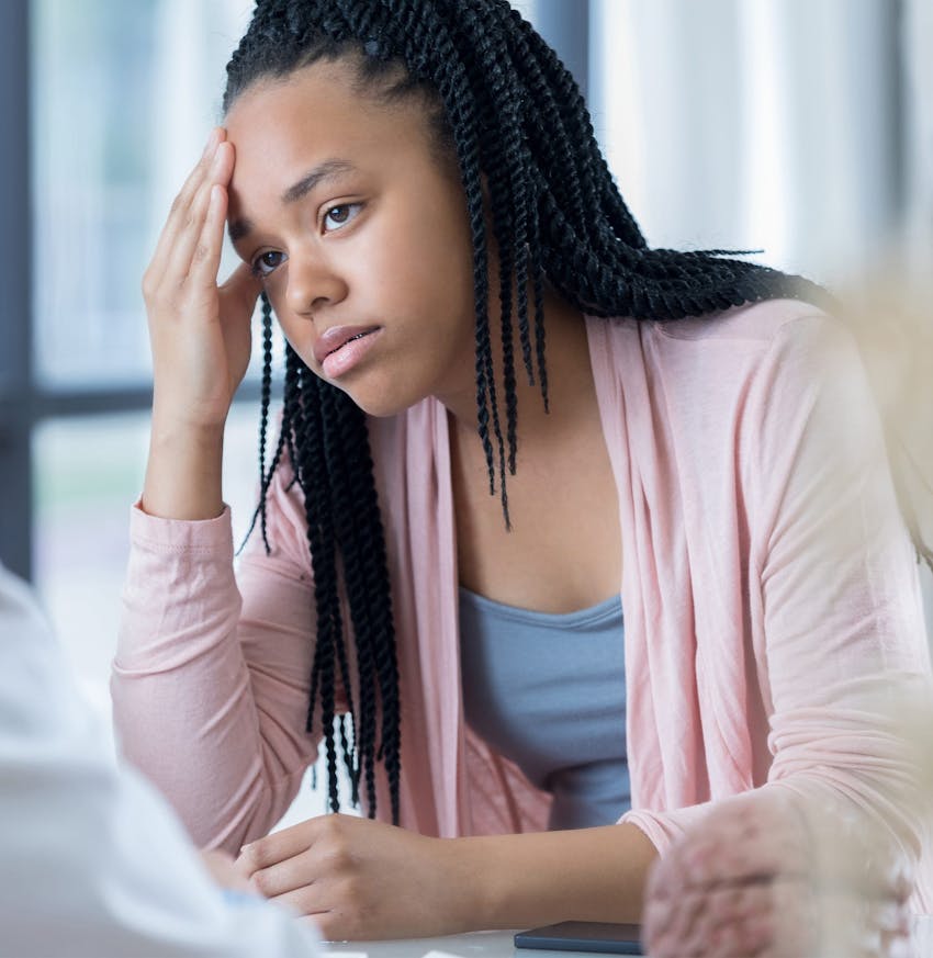 there is a woman sitting at a table with a laptop and a man sitting at a table