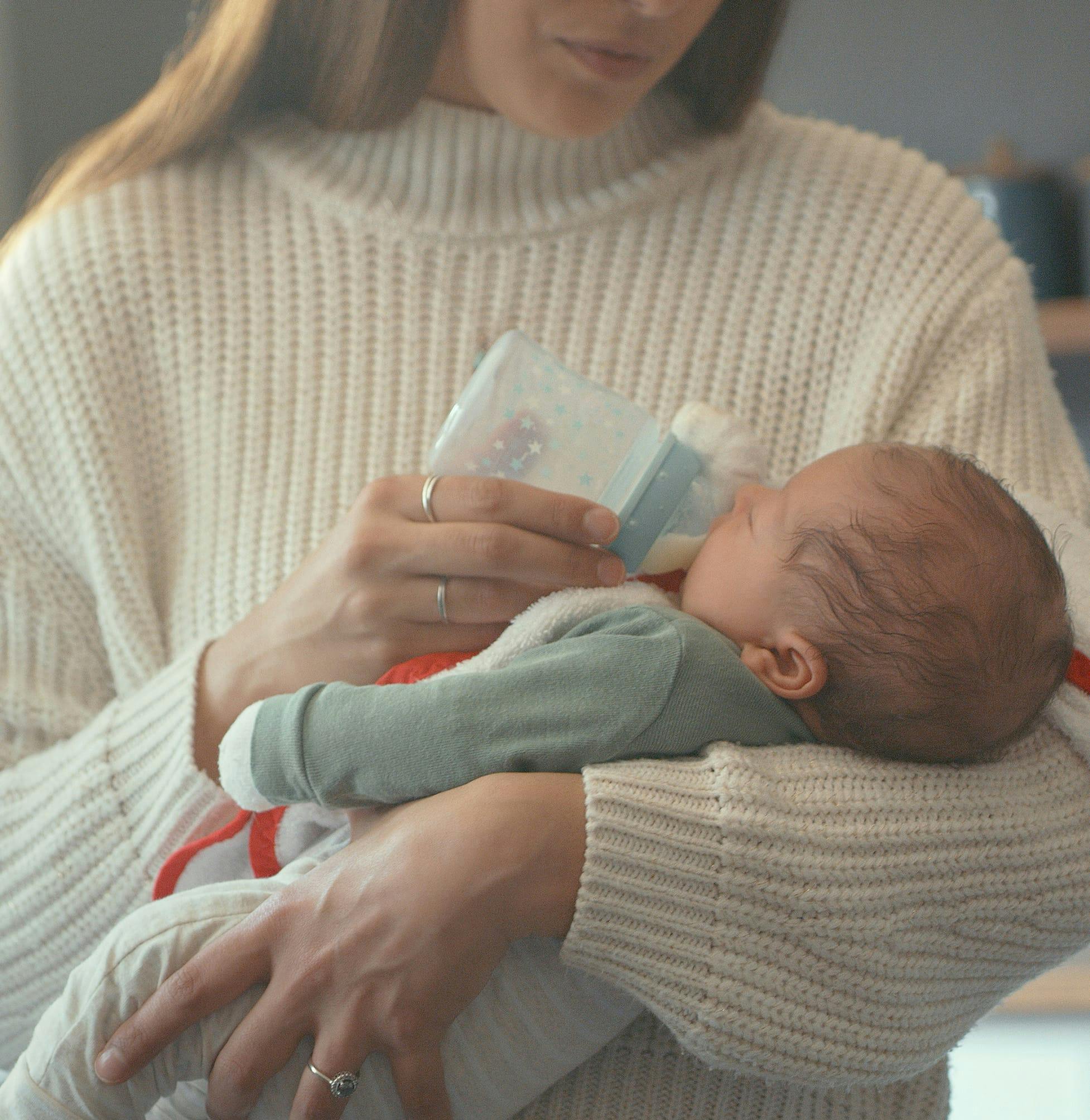 woman holding a baby and bottle in her arms
