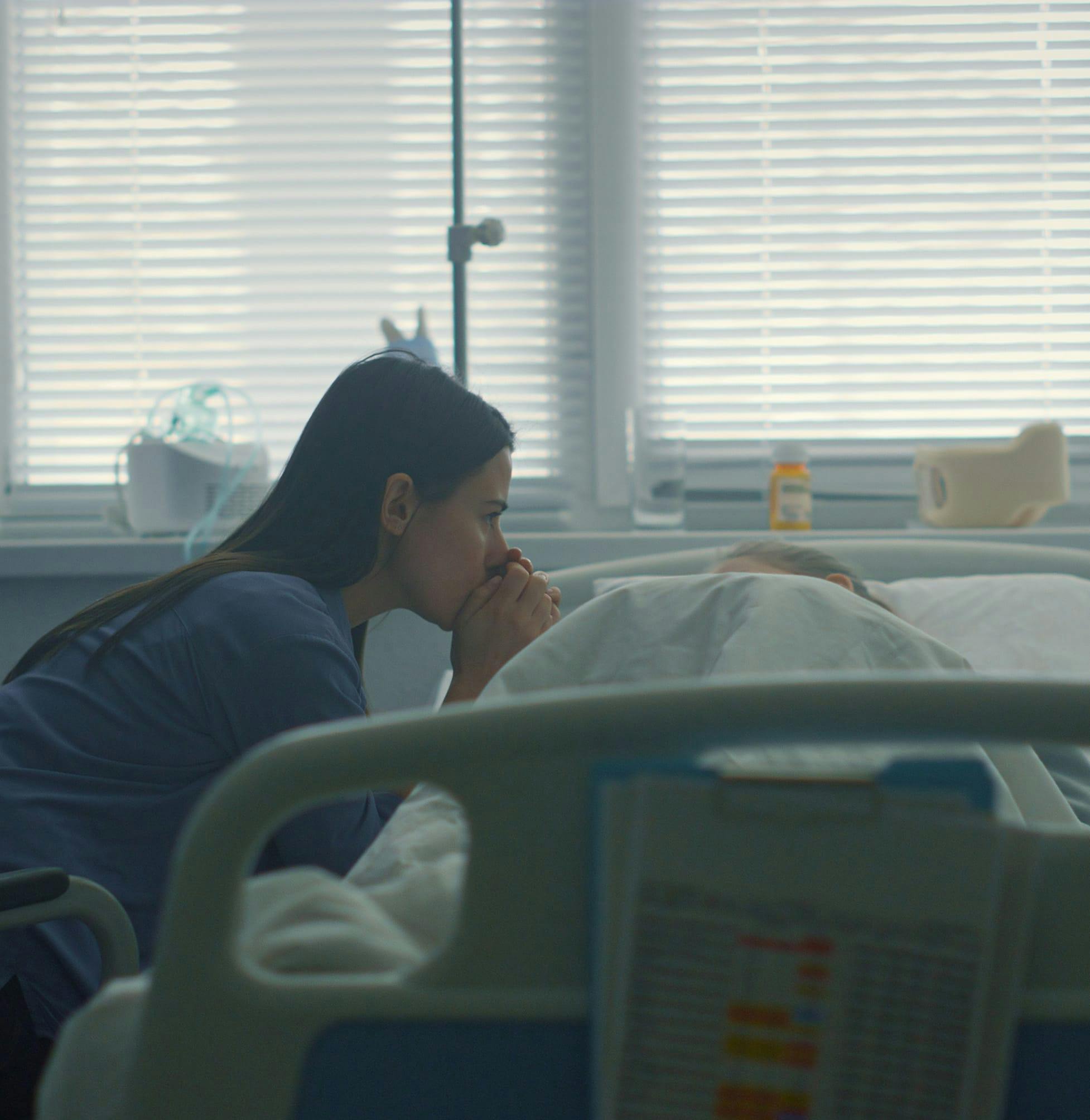 Worried woman next to a hospital bed