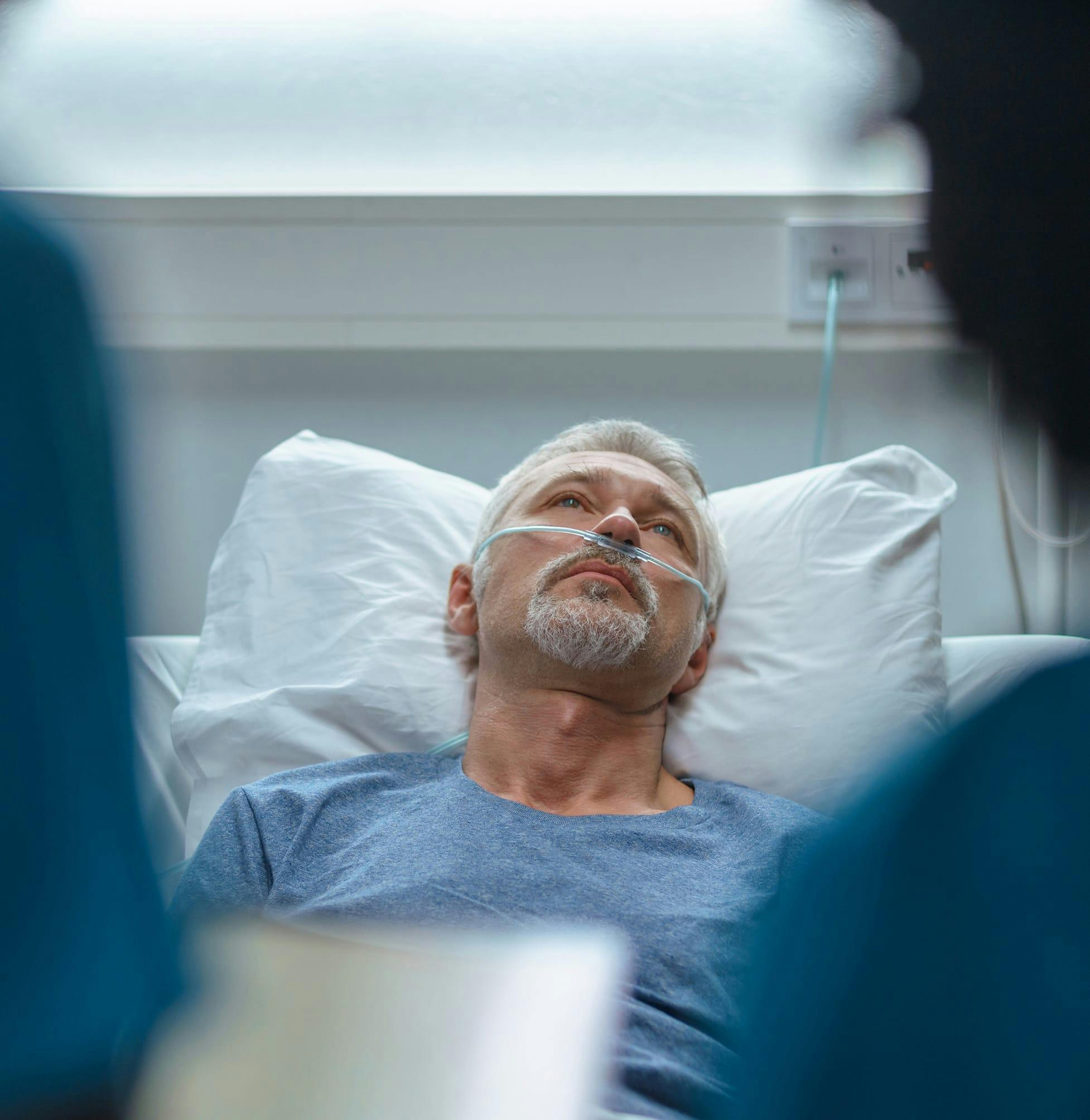 Man looking forlorn in a hospital bed