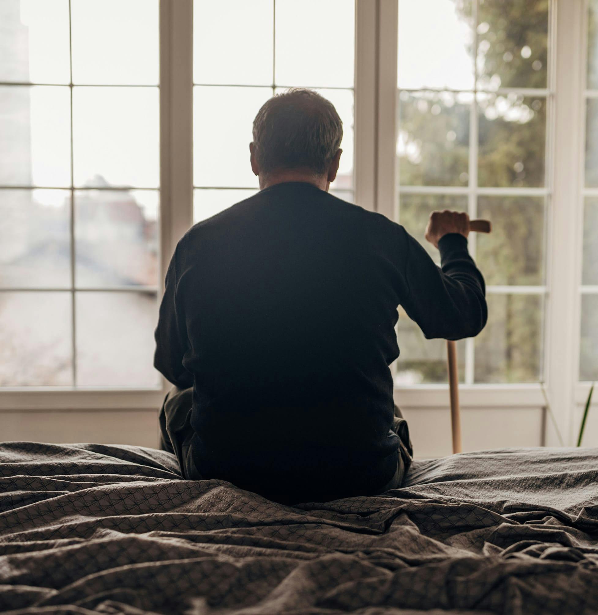 Elderly person looking out the window