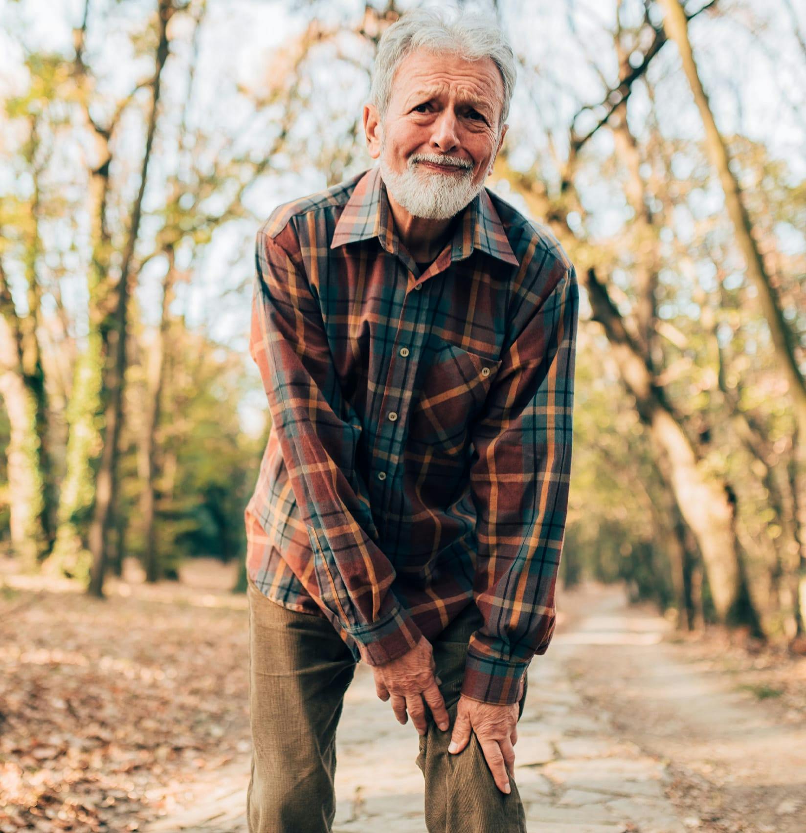 Man leaning over and holding his leg