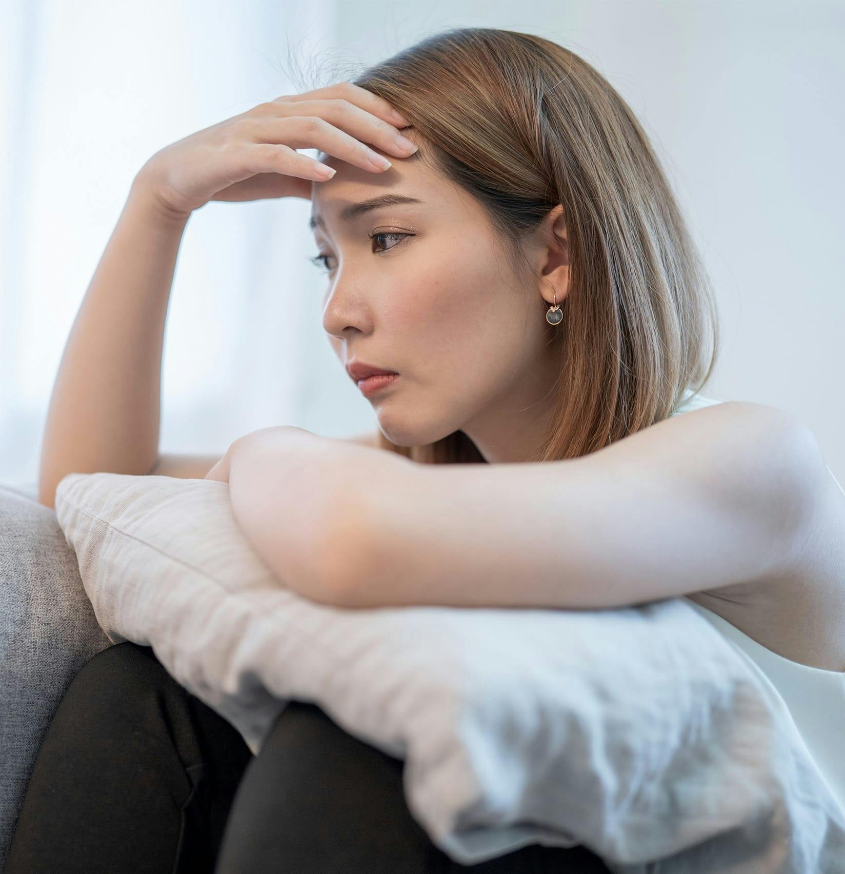 Woman looking distressed on her couch