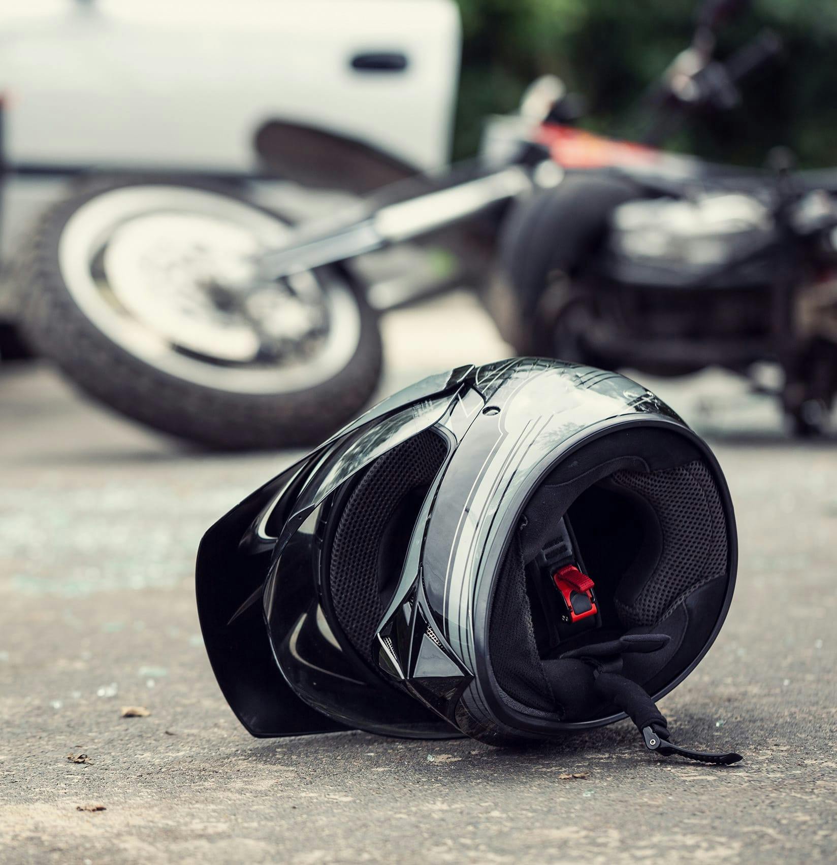 Motorcycle on its side and a helmet on the pavement