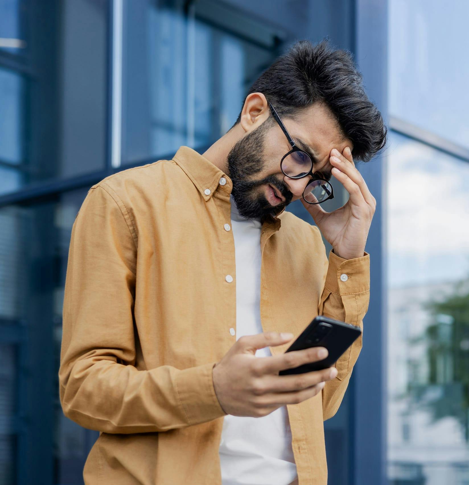 Man stressed out looking at his phone