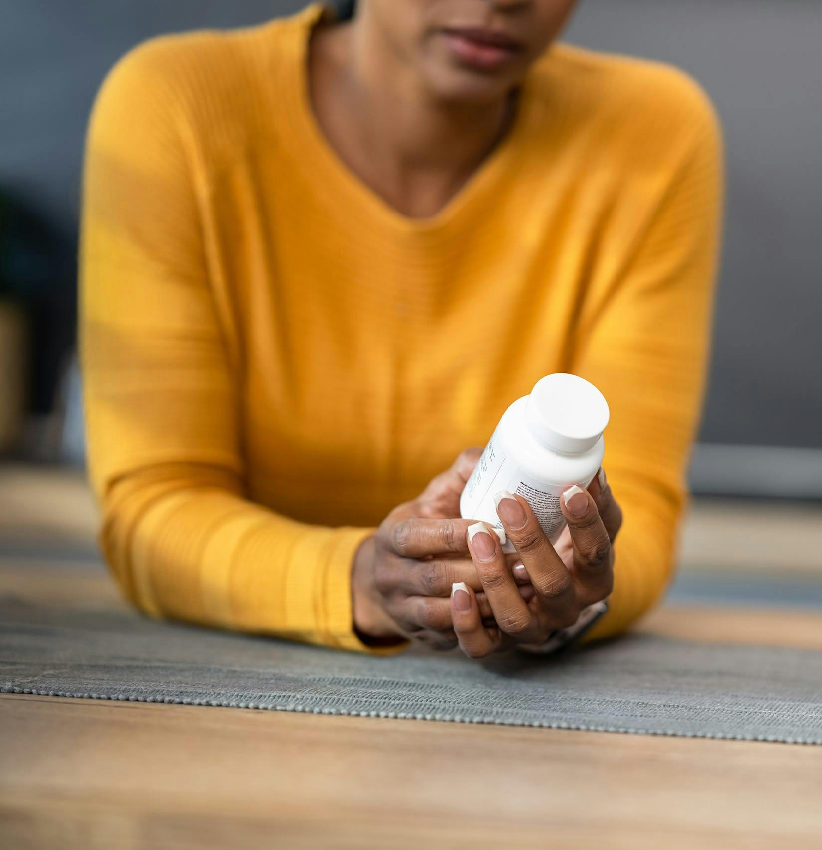 Woman looking at a medicine bottle