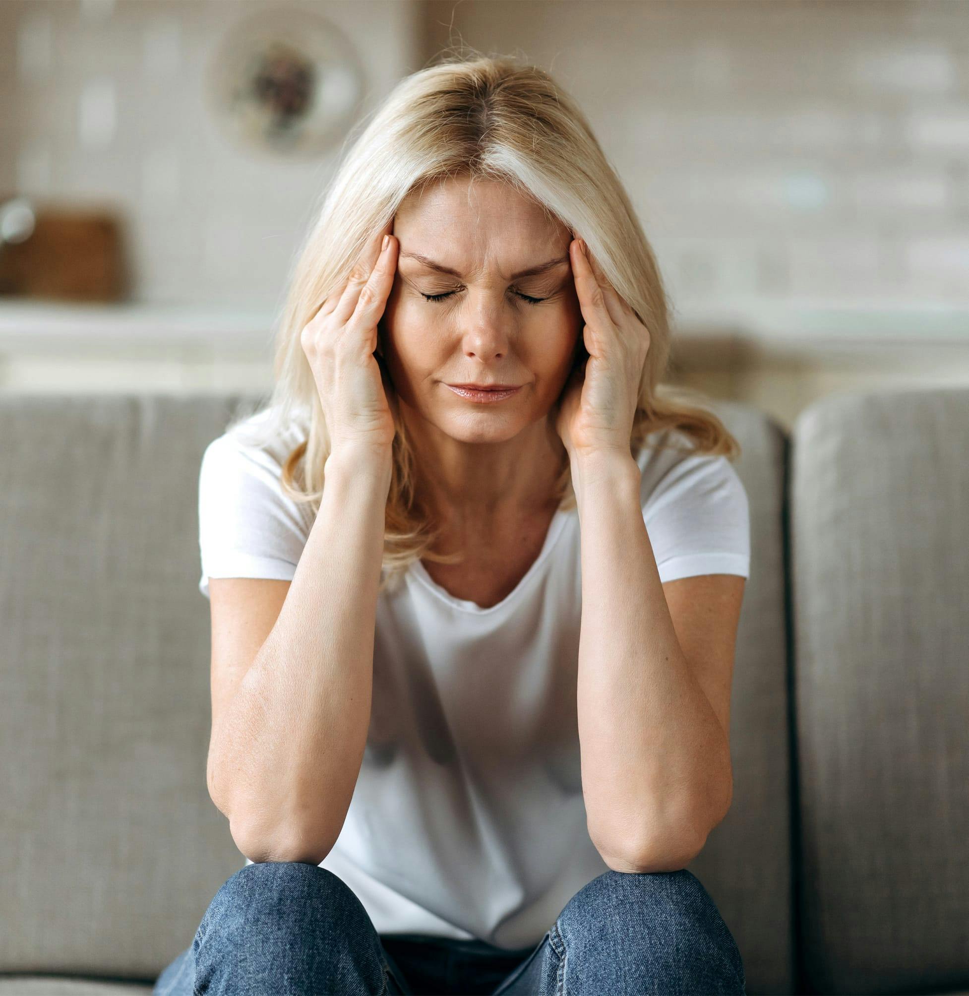 Woman holding her temples in pain