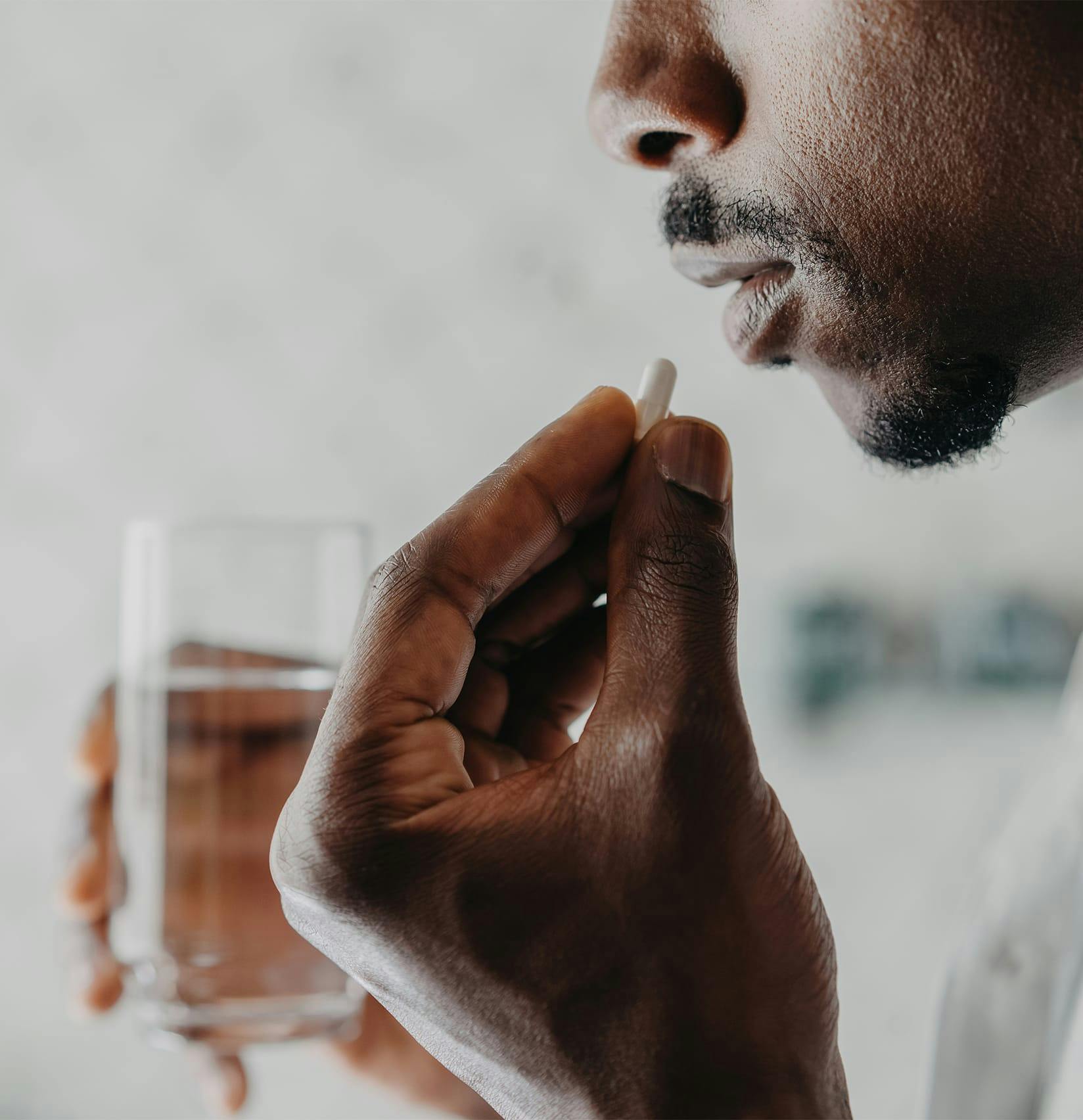 Man putting a pill in his mouth