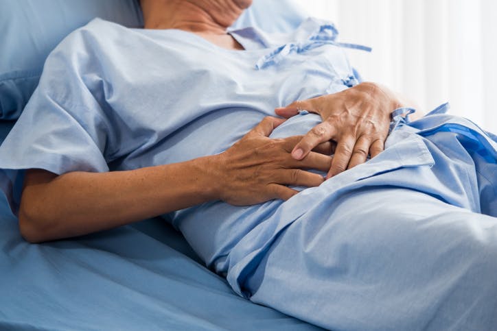 A man laying in hospital bed in pain