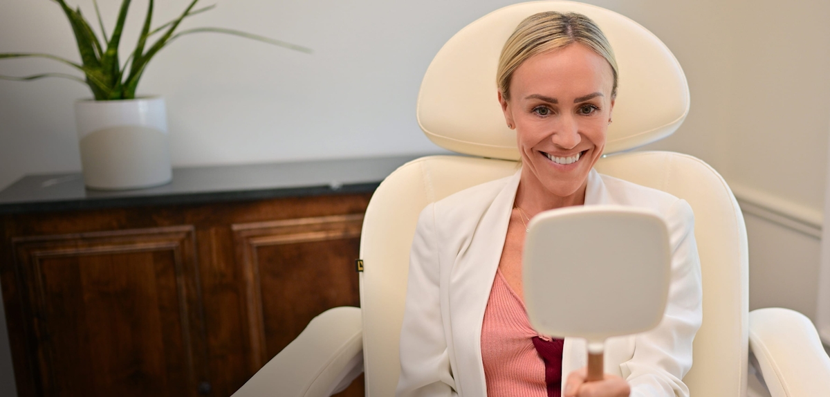 Woman looking in a mirror while in a patient chair