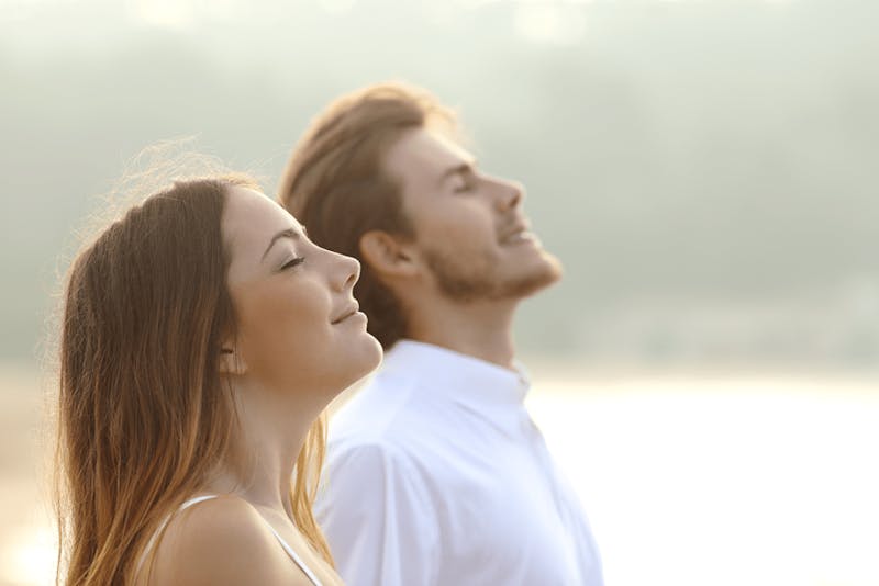 man and woman looking up towards the sky while smiling