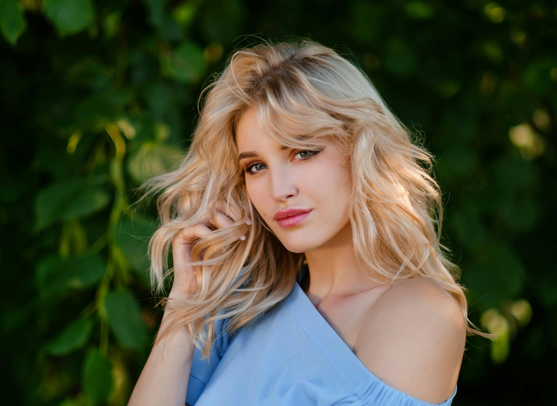 woman with blonde hair wearing a blue top