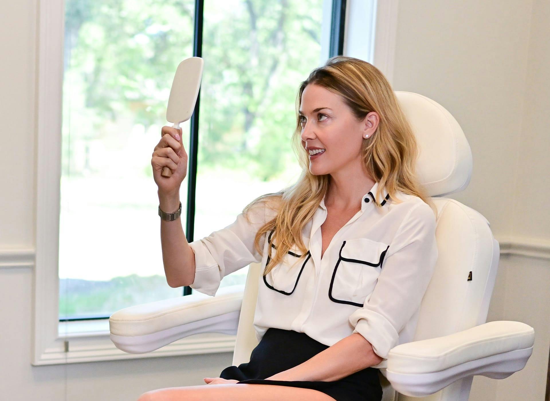 woman holding a hand mirror looking at face