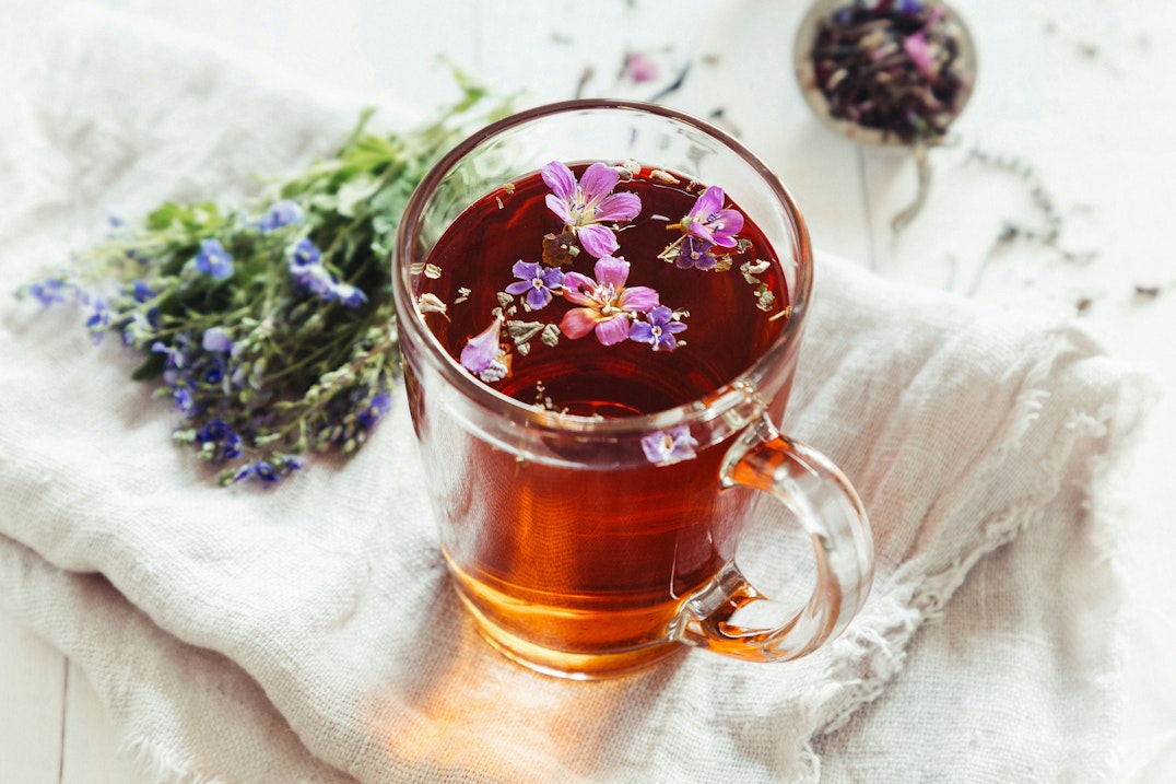 https://unsplash.com/photos/a-glass-mug-filled-with-tea-next-to-a-bunch-of-flowers-O7sKj9cjZOk