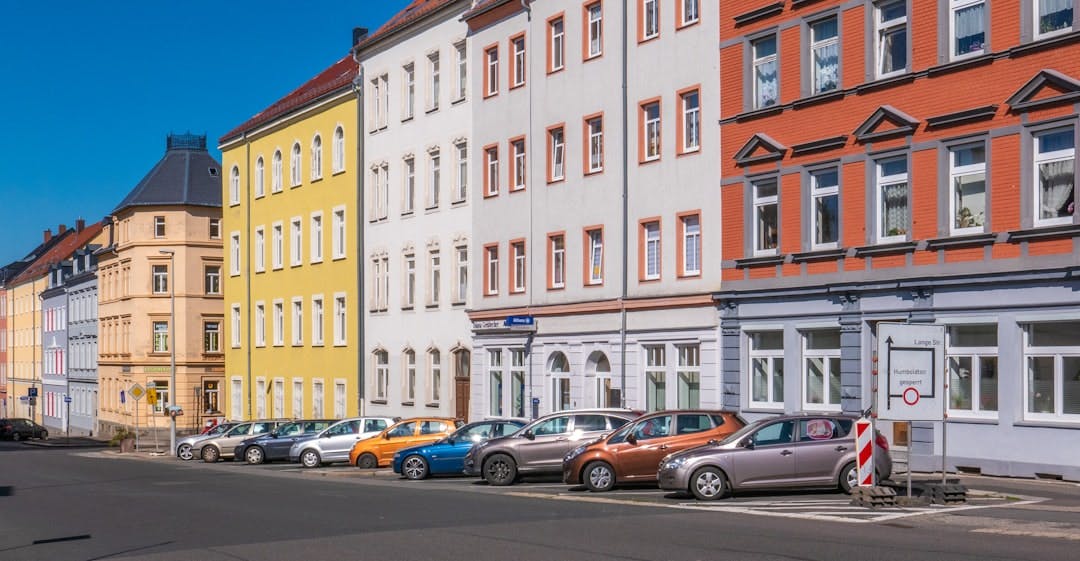 Bunte Altbaufassaden mit parkenden Autos entlang einer deutschen Straße.