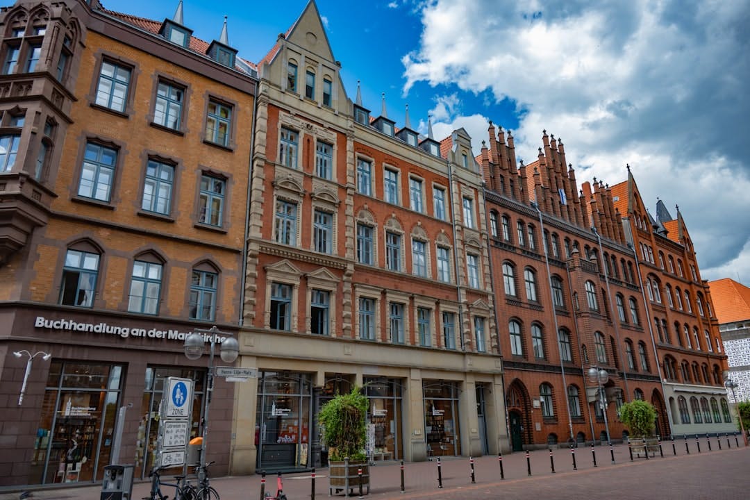 Historic brick buildings with ornate gables on a market square.
