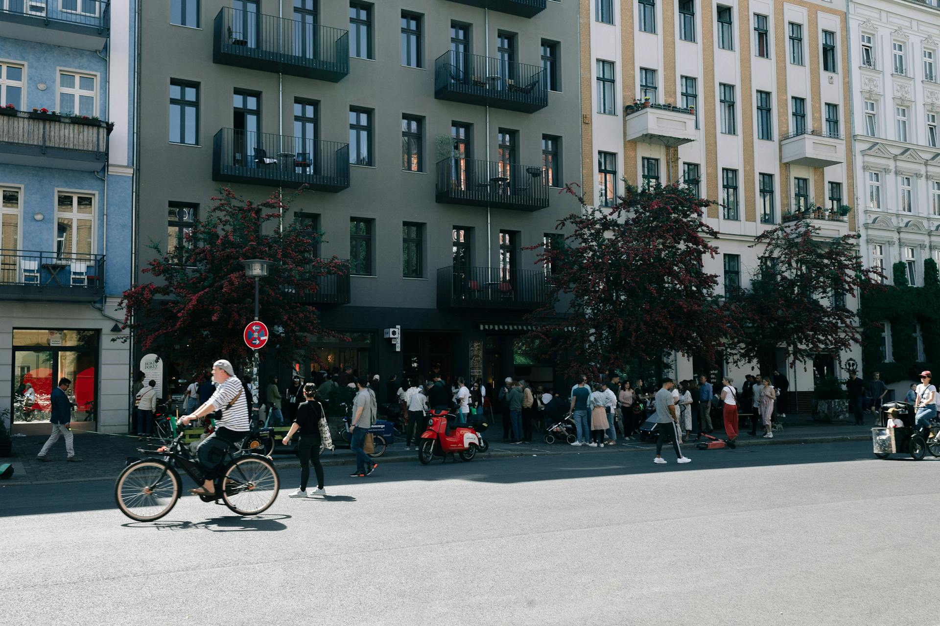 Cyclist on a Berlin street between residential buildings (Photo by Nataliya Shemetova on Unsplash)