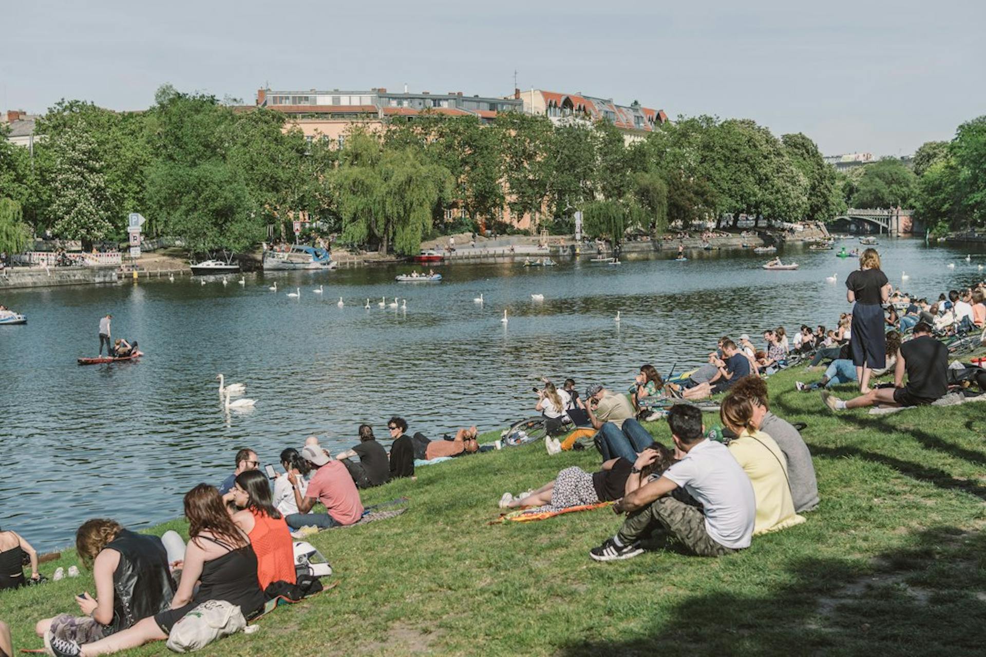 Junge Leute entspannen auf der Wiese am Landwehrkanal in Berlin (Photo by Fionn Große on Unsplash)