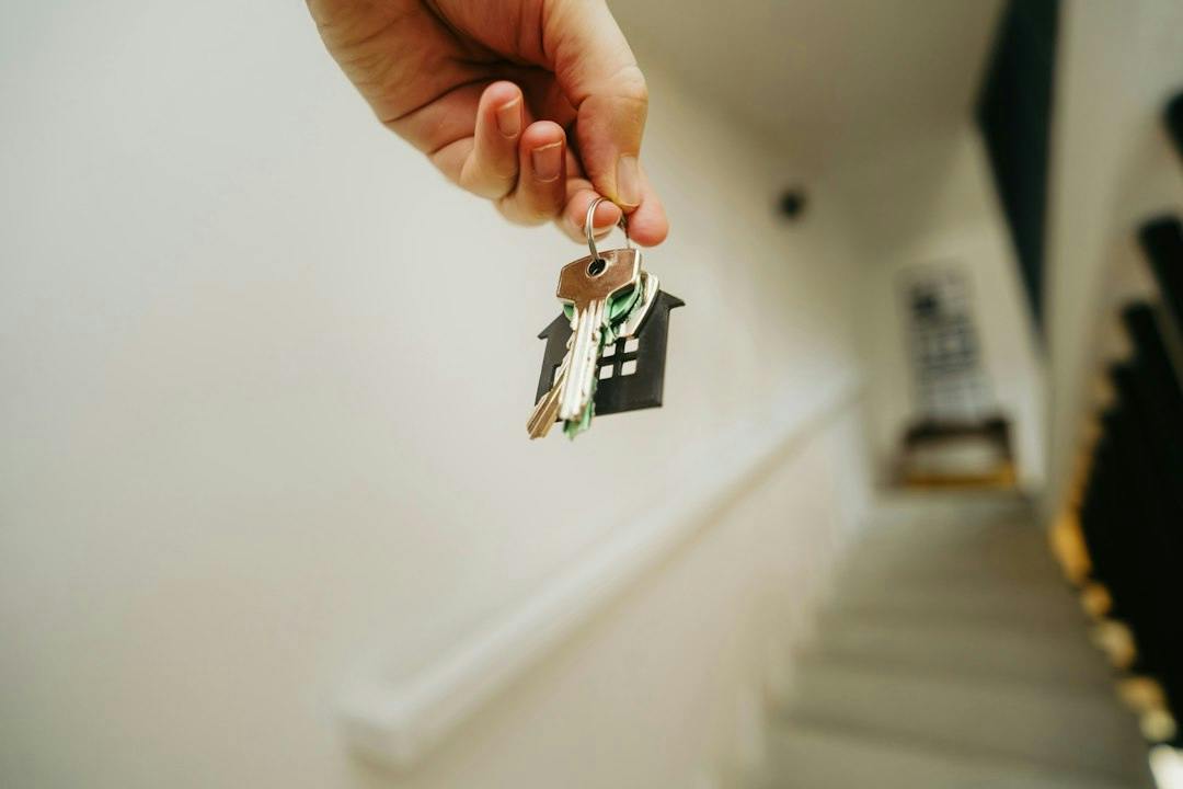 Hand hält einen Schlüsselbund im Treppenhaus (Photo by Jakub Żerdzicki on Unsplash)