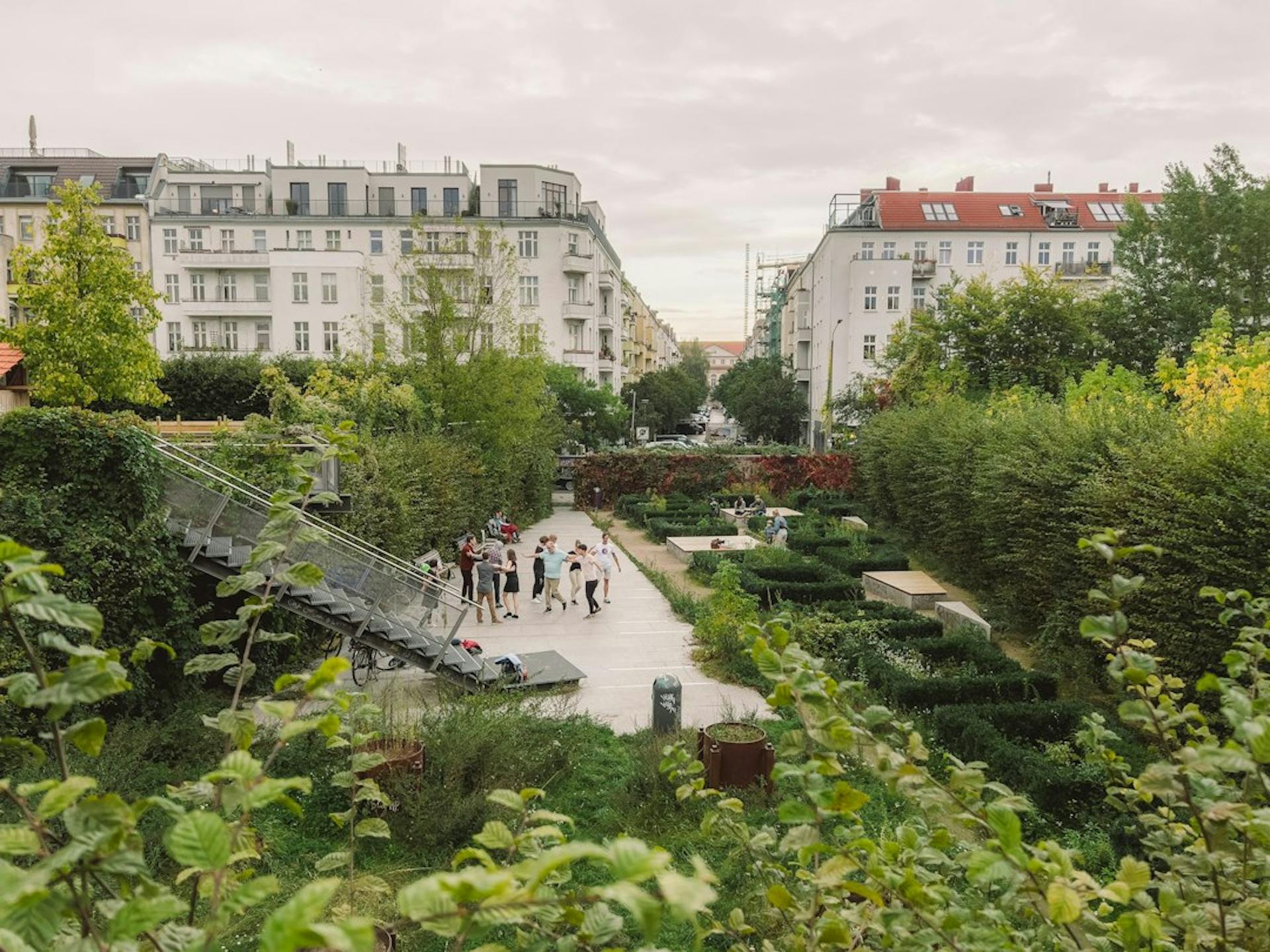Menschen tanzen in einem Berliner Park, umgeben von Altbauten (Photo by Fionn Große on Unsplash)