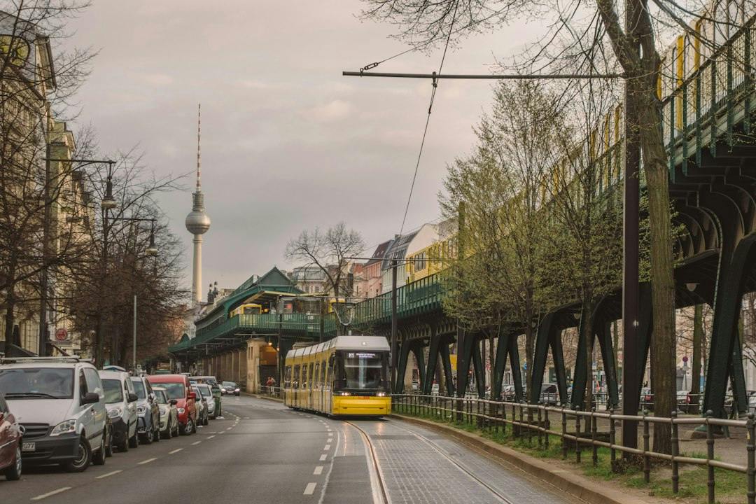 Gelbe Tram neben der Hochbahn der U2 in Prenzlauer Berg, dahinter der Fernsehturm (Photo by Fionn Große on Unsplash)