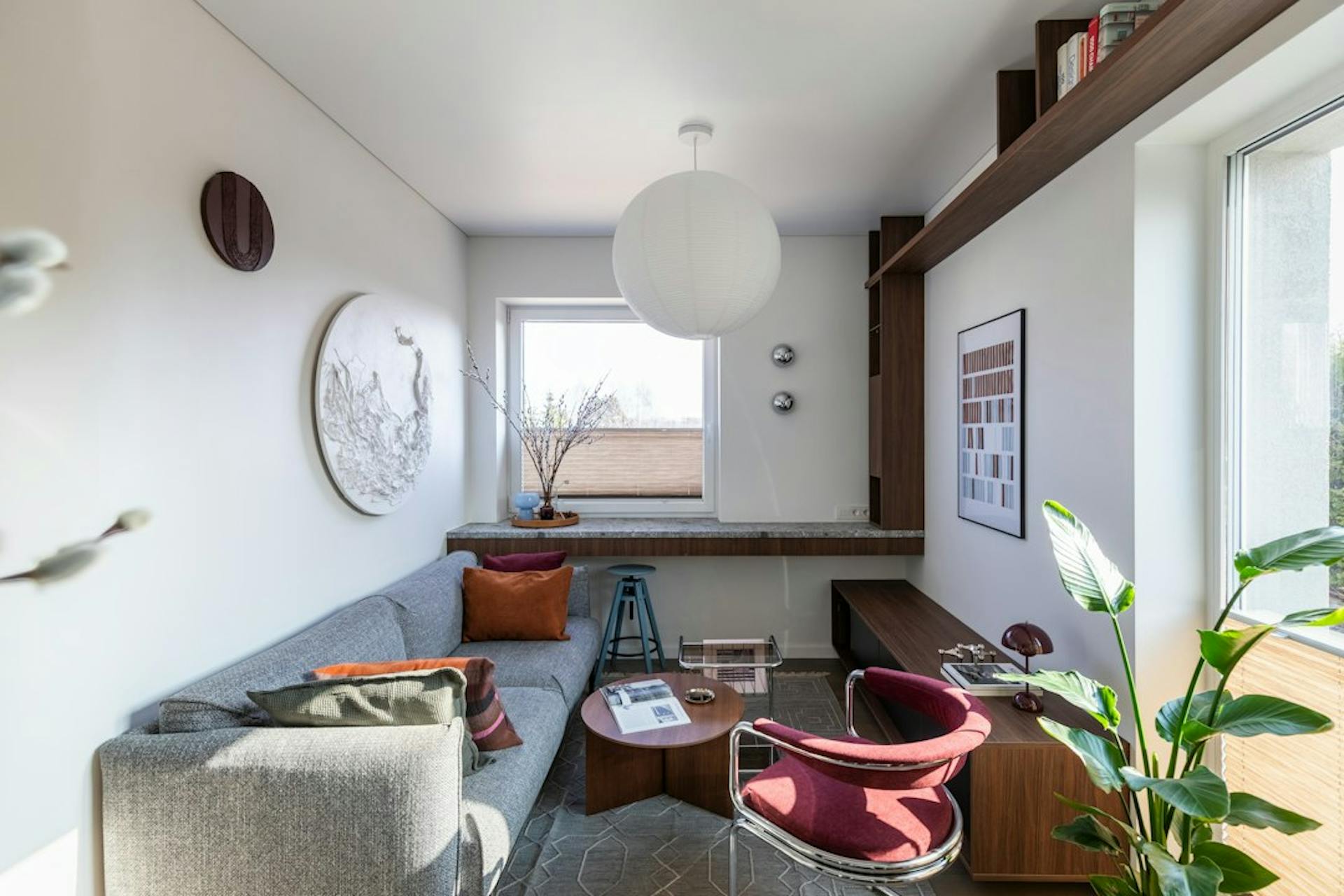 Compact, bright living room with a sofa, armchair and shelves in a small apartment (Photo by Irena Oze on Unsplash)