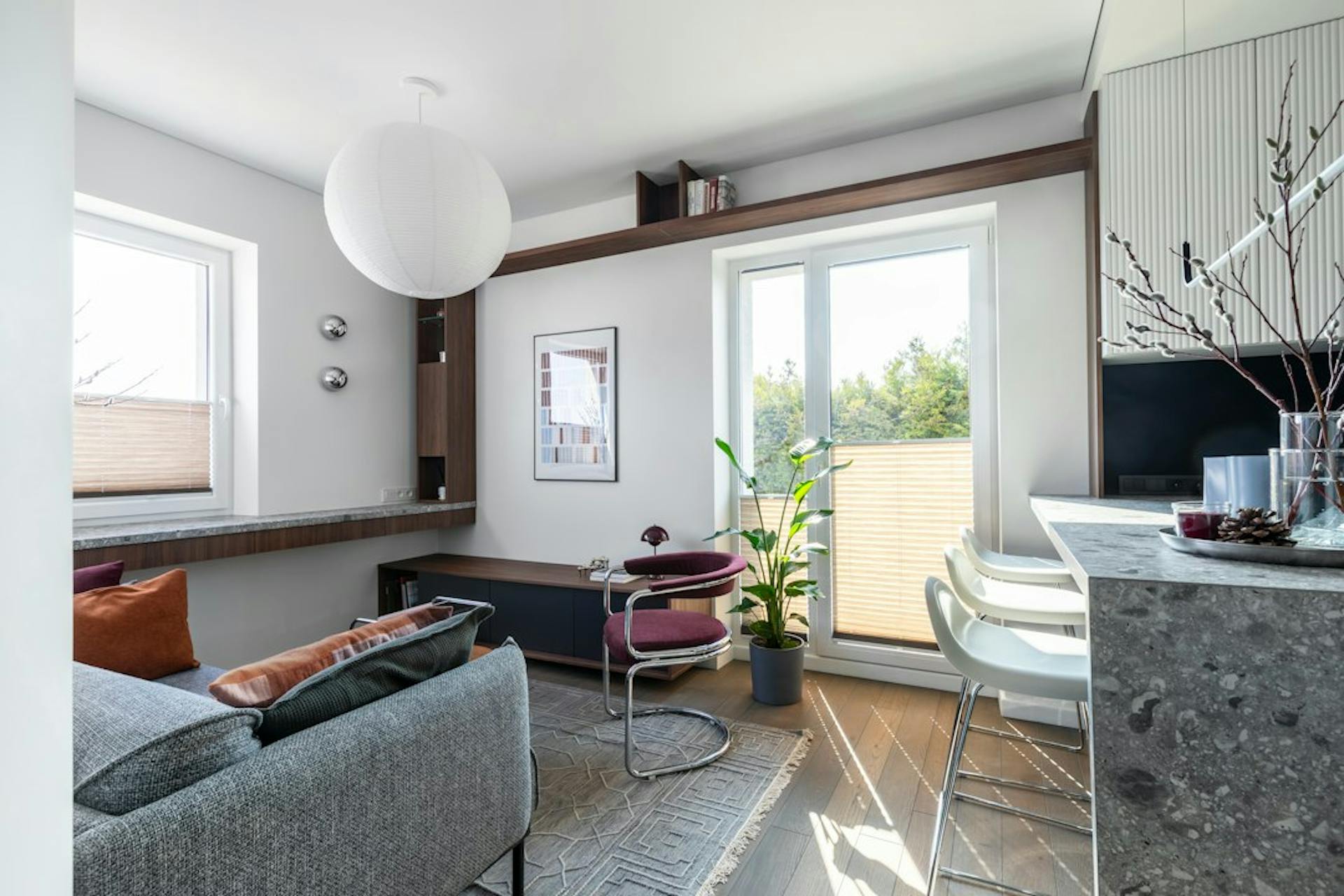 Sunny small apartment with a living area, kitchen counter and balcony door (Photo by Irena Oze on Unsplash)