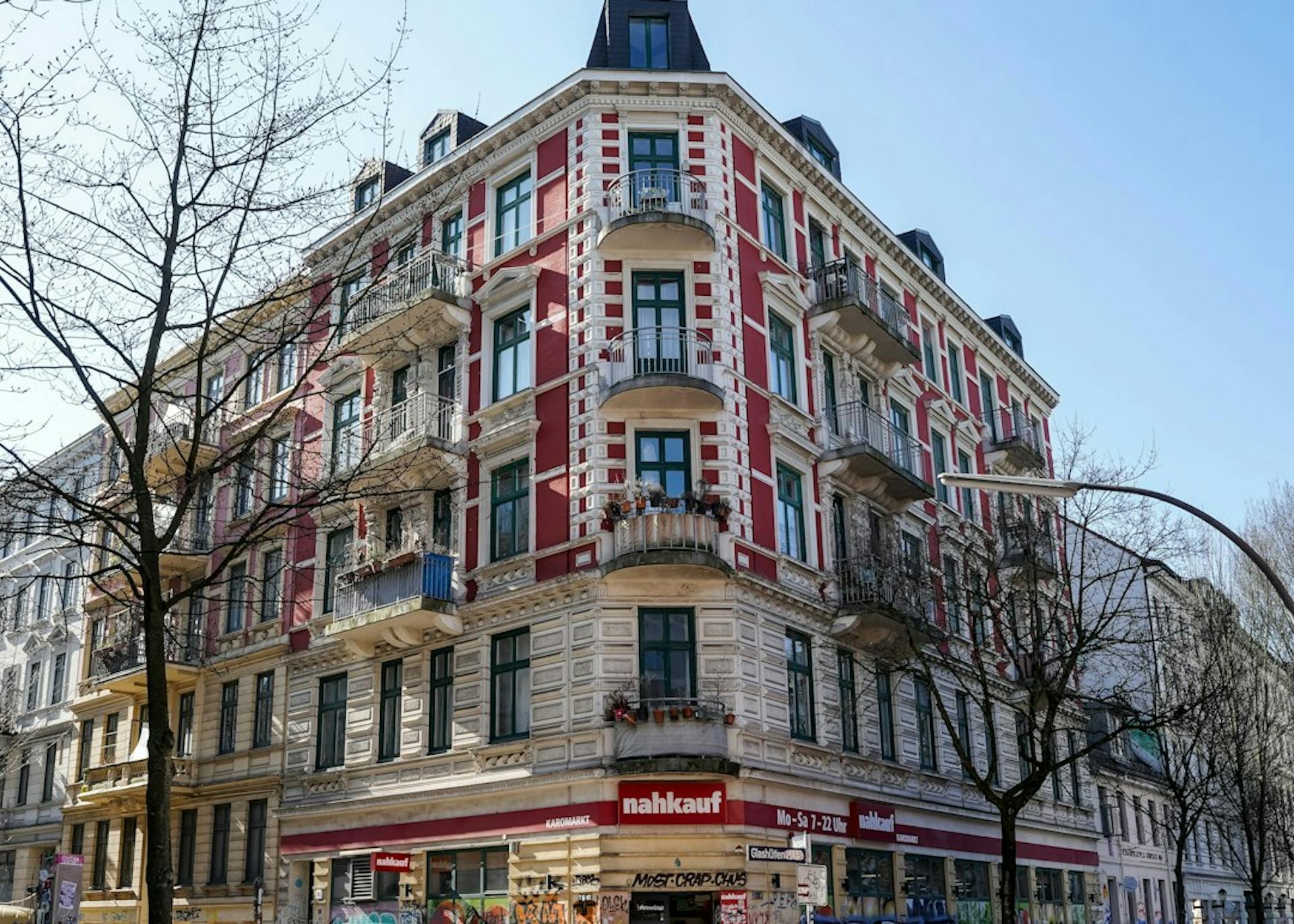 Old corner apartment building with a red and white facade in Hamburg (Photo by Wolfgang Weiser on Unsplash)