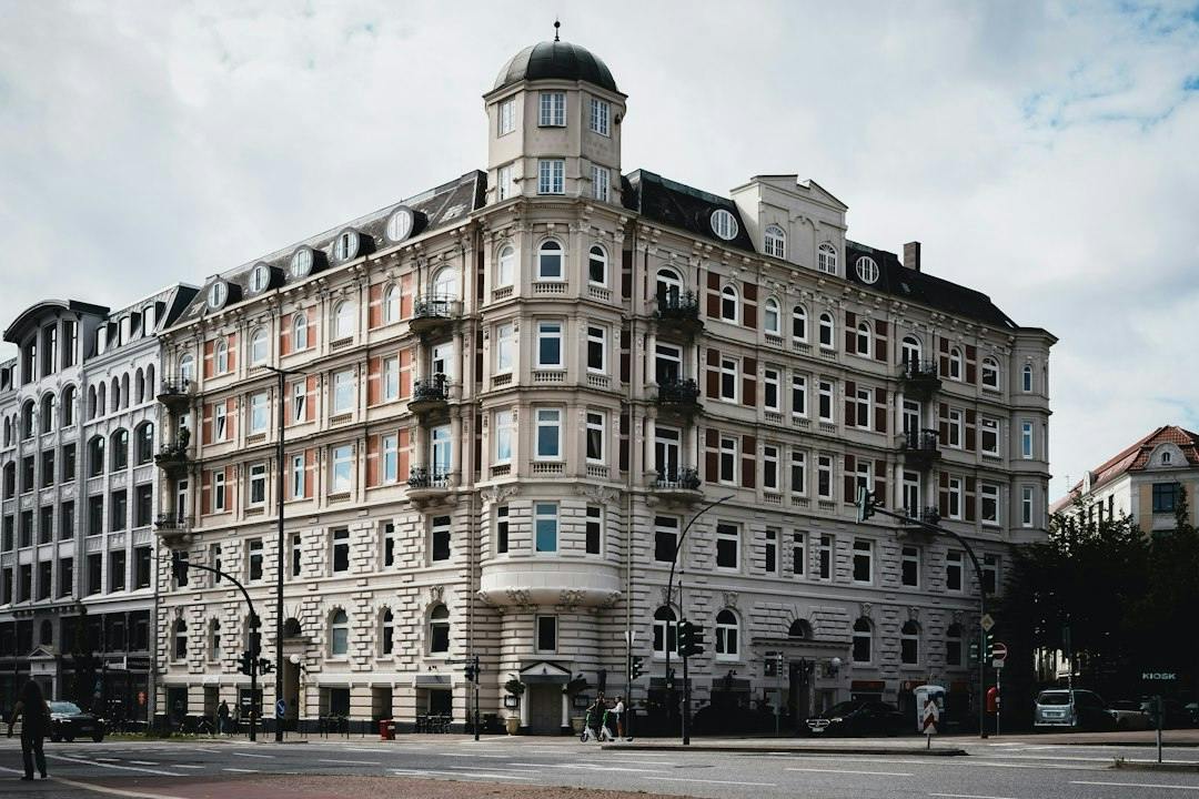 Corner apartment building with a domed tower on a street in Hamburg (Photo by Wolfgang Weiser on Unsplash)