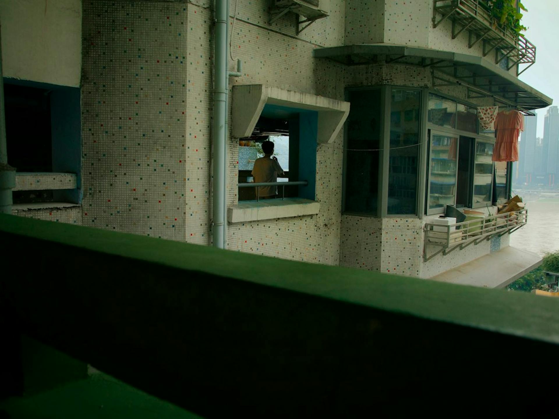 Young couple drinking coffee on a balcony of a city apartment (Photo by Yiquan Zhang on Unsplash)