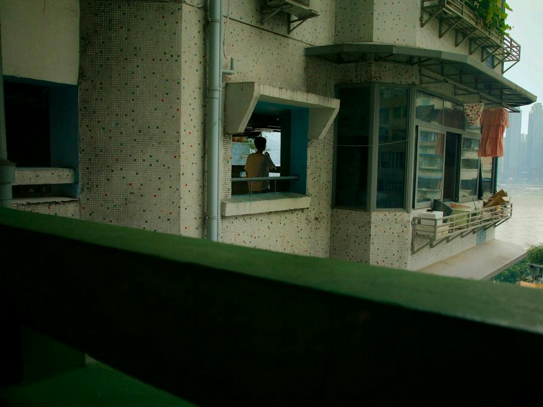 Young couple drinking coffee on a balcony of a city apartment (Photo by Yiquan Zhang on Unsplash)