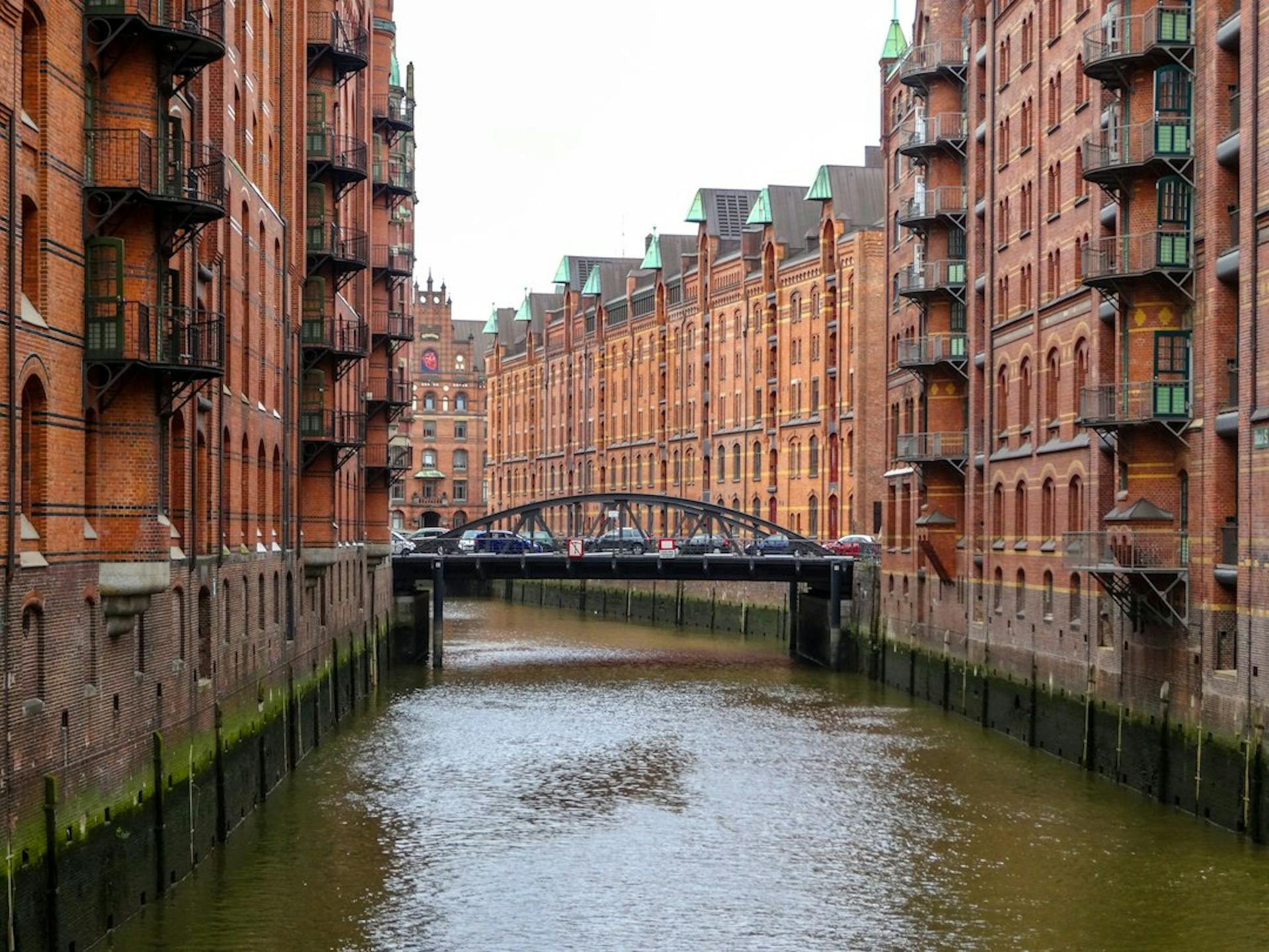 Historic red brick residential buildings along a canal in Hamburg (Photo by Nikolai Kolosov on Unsplash)