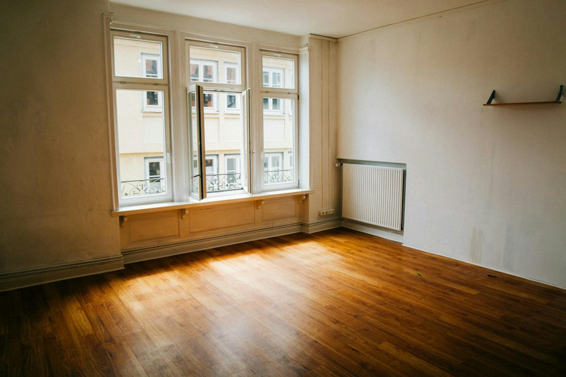 Young couple viewing an empty, bright apartment with large windows (Photo by Christian Lue on Unsplash)