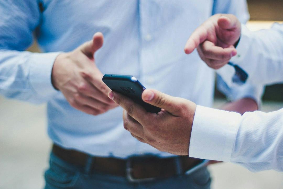 Two people looking at a smartphone together (Photo by Luis Villasmil on Unsplash)