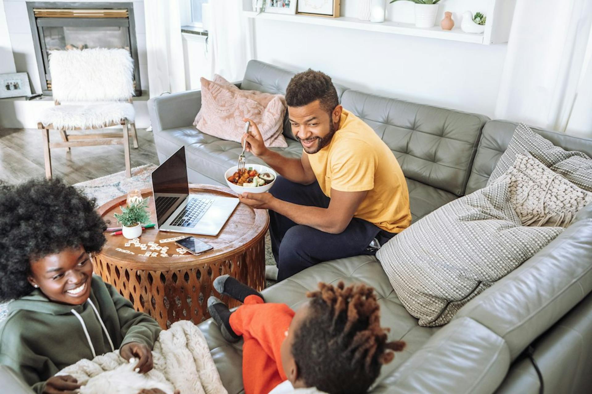 Junge Familie entspannt auf dem Sofa im Wohnzimmer (Photo by Jimmy Dean on Unsplash)