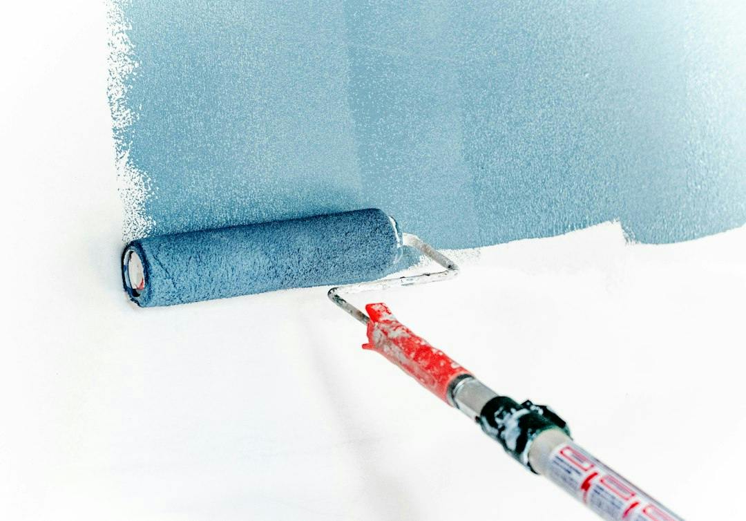 Paint roller spreading light blue paint on a white wall (Photo by Theme Photos on Unsplash)