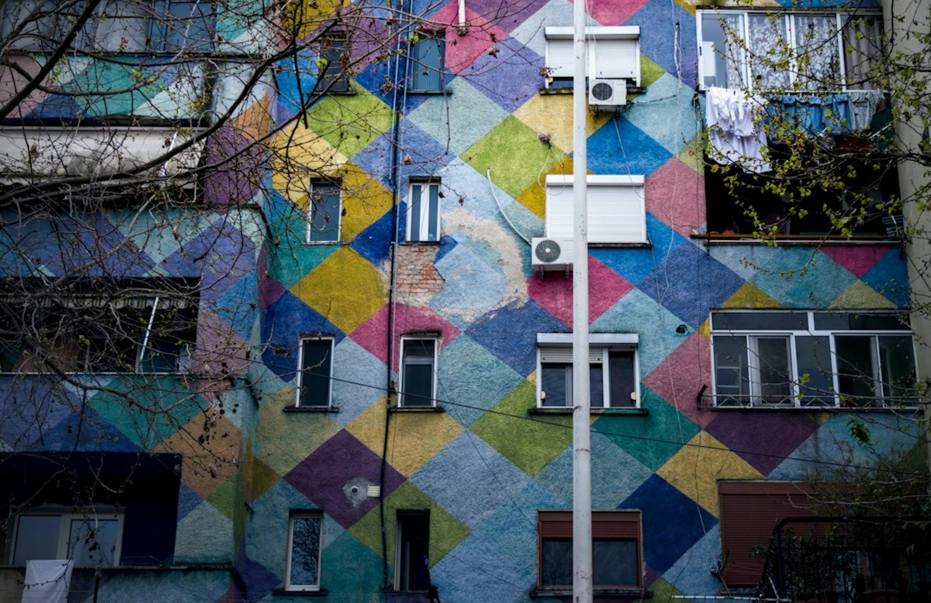 Apartment block painted in colourful diamond patterns (Photo by Aldo Vukaj on Unsplash)