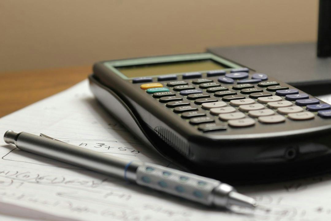 Calculator and pen lying on handwritten notes (Photo by Aaron Lefler on Unsplash)